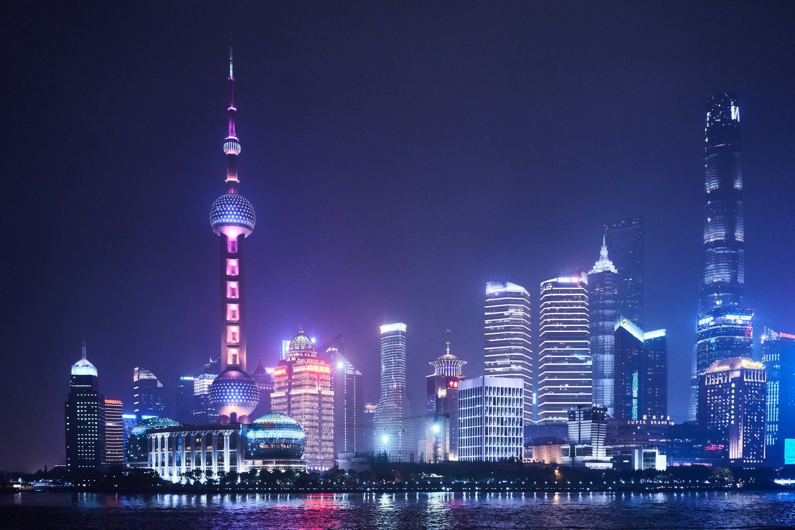 The Oriental Pearl Tower and illuminated Pudong skyscrapers reflected in Shanghai’s Huangpu River.
