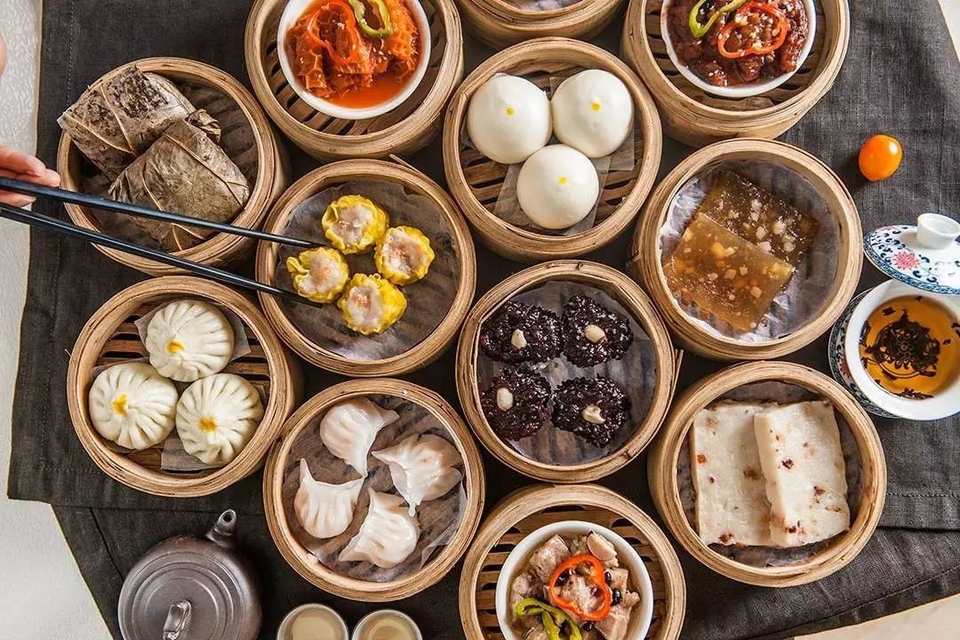 A colorful selection of Cantonese dim sum arranged in bamboo steamers.