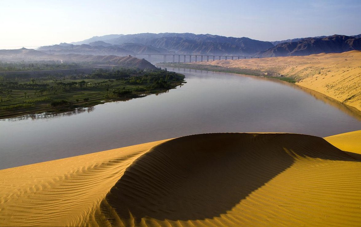 Golden dunes curve above the Yellow River at Shapotou in Ningxia.