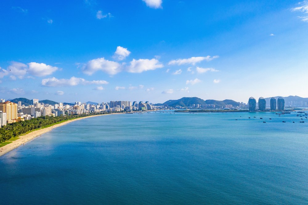 Sanya Bay’s sandy coastline, palms and city skyline on Hainan Island.