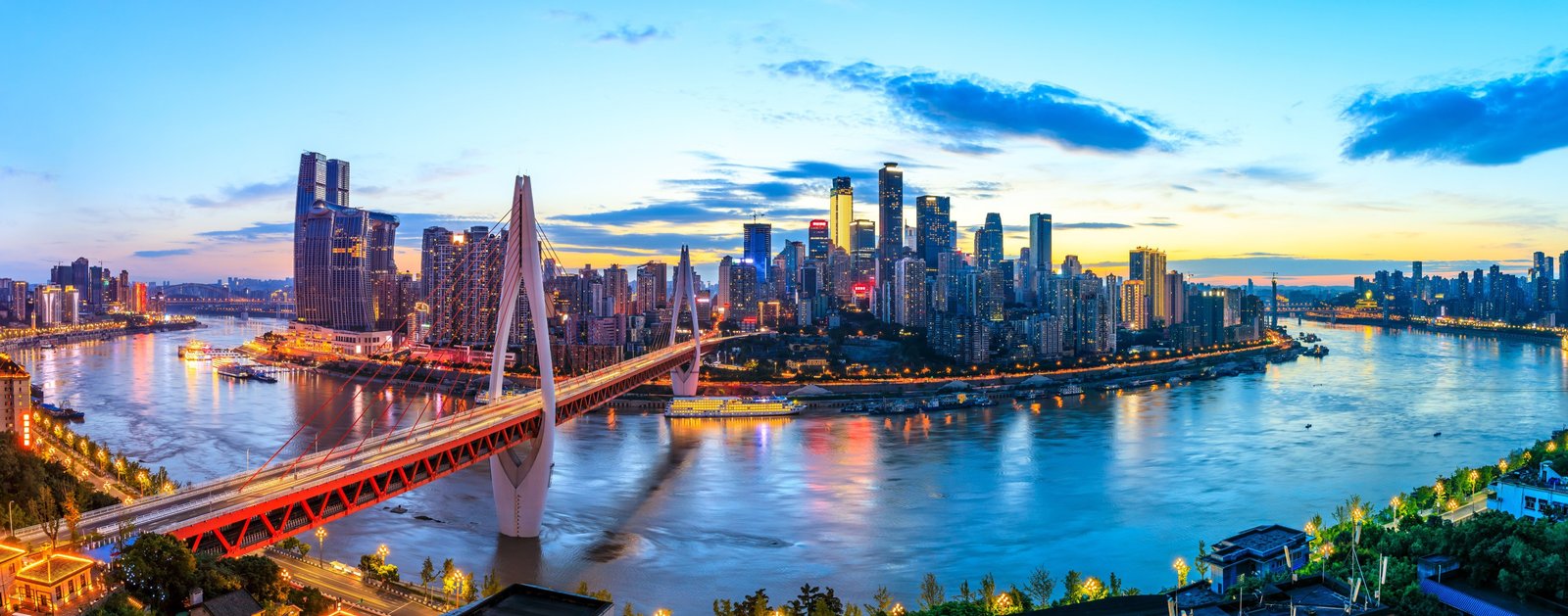 Qiansimen Bridge spans Chongqing’s Jialing River beneath a layered skyline at sunset