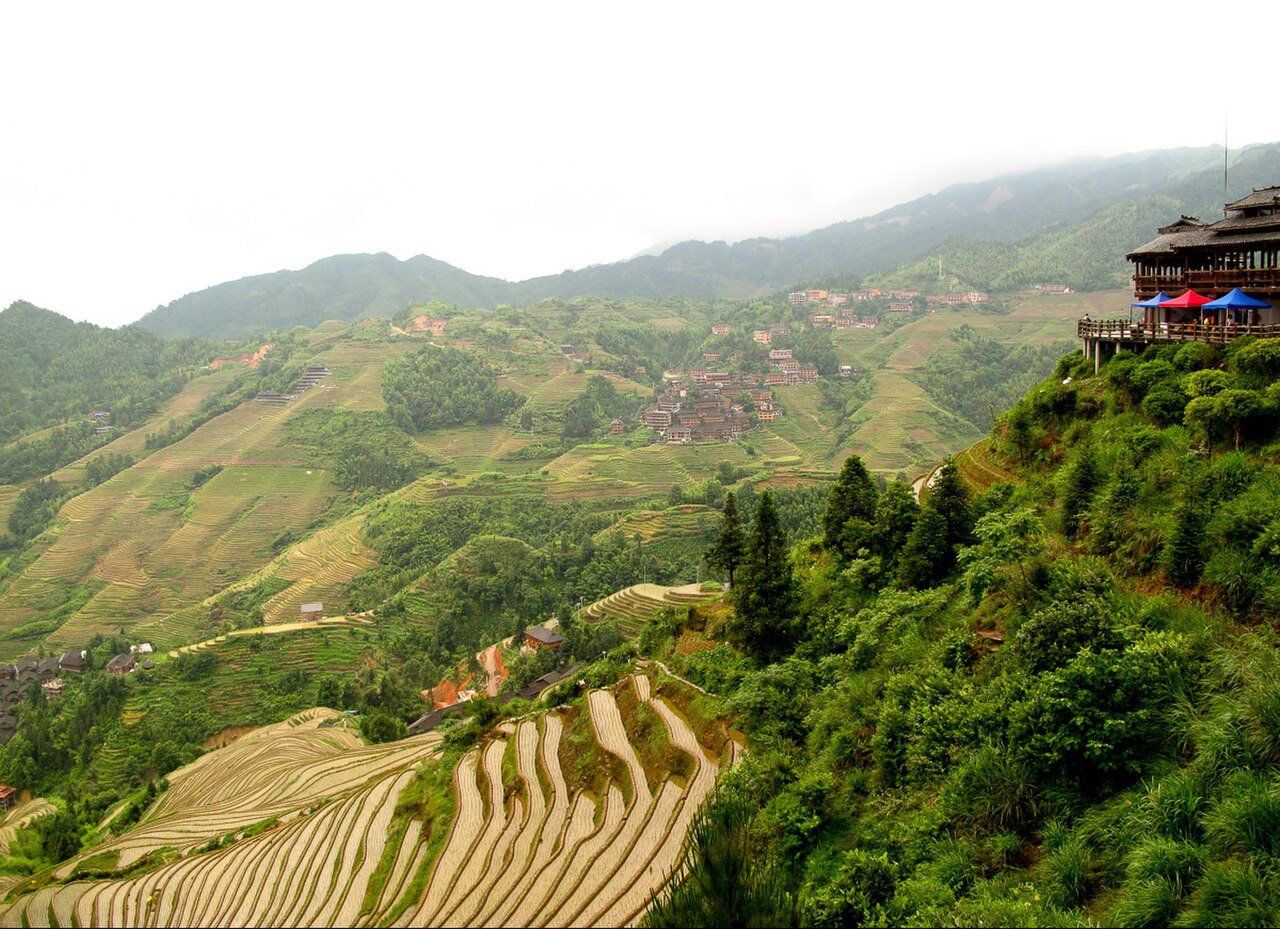 Cultivated hillsides and village buildings among the Longji rice terraces.